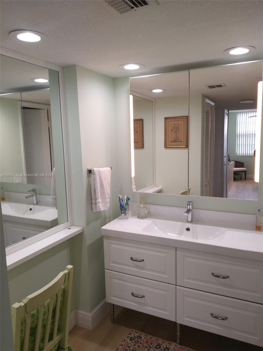 3510 Oaks Way, Unit 509 Pompano Beach, FL 33069 - Photo 21 of 36 a bathroom with a double vanity sink and a mirror