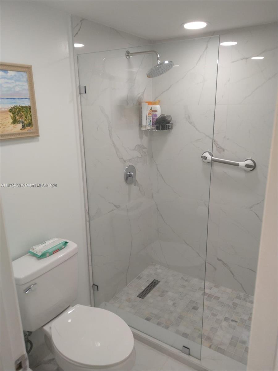 3510 Oaks Way, Unit 509 Pompano Beach, FL 33069 - Photo 22 of 36 a bathroom with a toilet and a shower