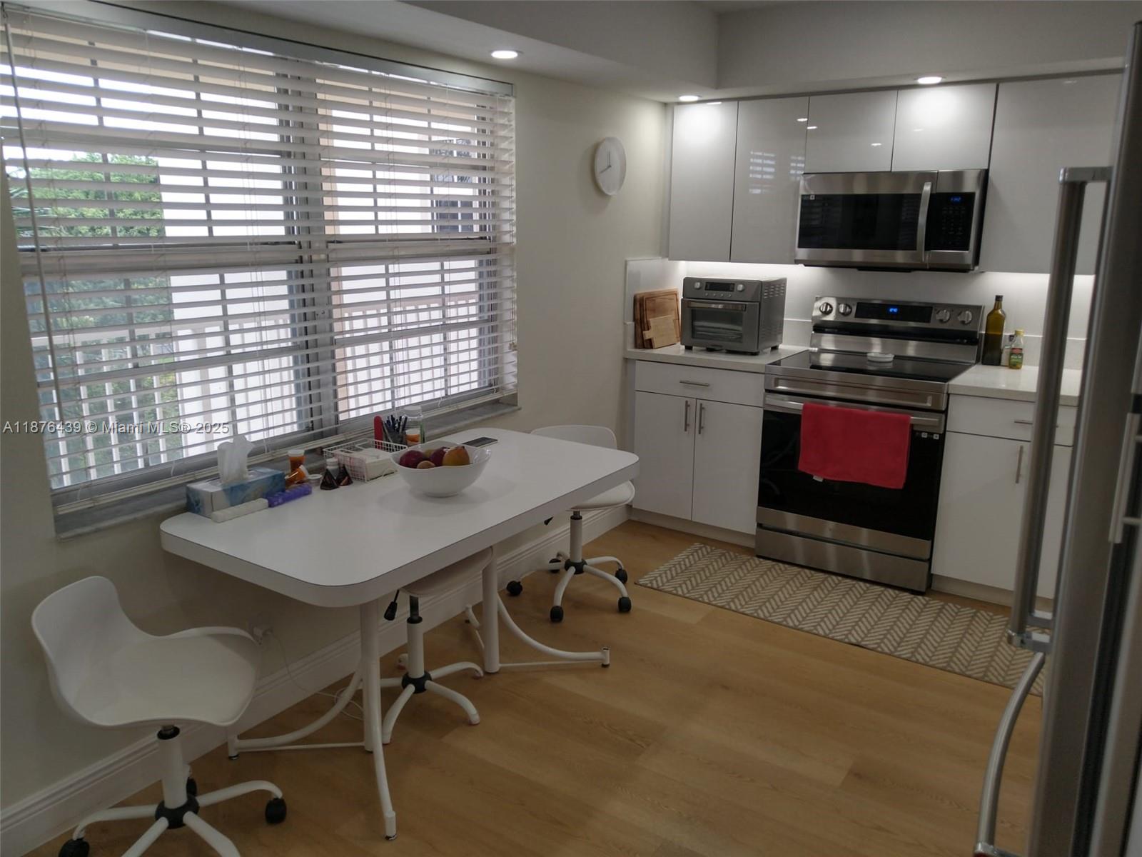 3510 Oaks Way, Unit 509 Pompano Beach, FL 33069 - Photo 34 of 36 a kitchen with a sink a counter and chairs