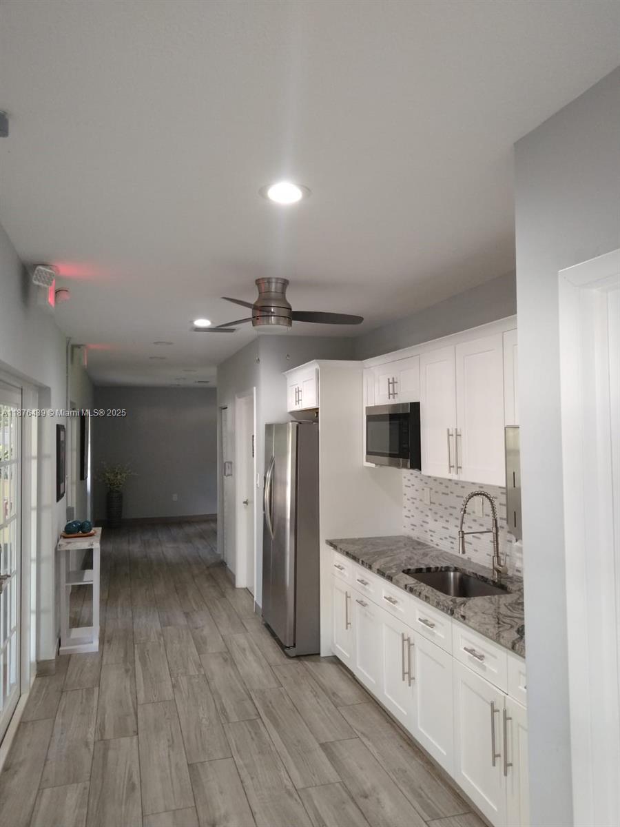 3510 Oaks Way, Unit 509 Pompano Beach, FL 33069 - Photo 5 of 36 a modern kitchen with stainless steel appliances granite countertop a refrigerator and a stove top oven