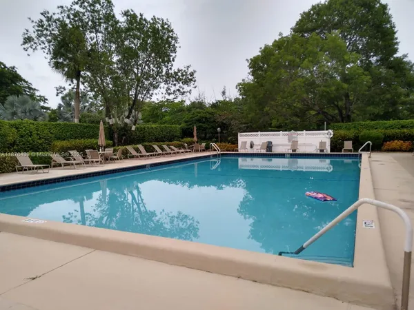 a view of a swimming pool with a patio and a yard
