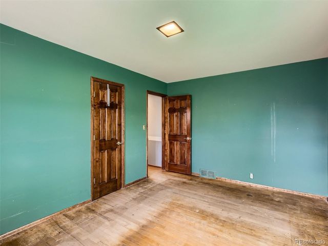 an empty room with closet and entrance