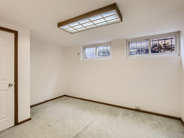 an empty room with a wall paintings and a window