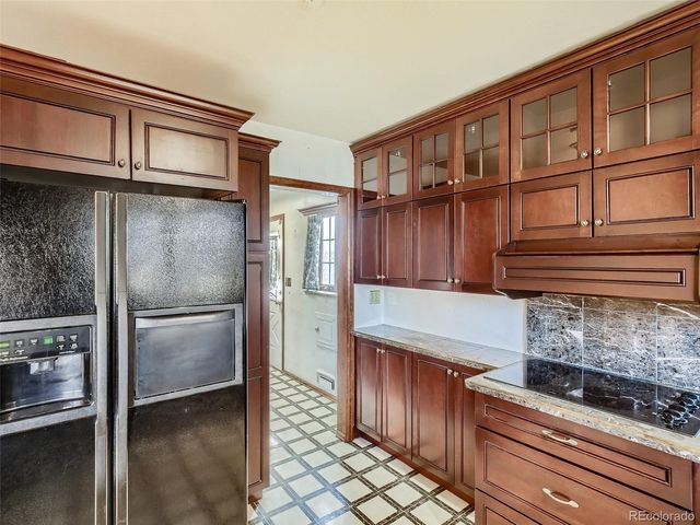 a kitchen with granite countertop a refrigerator and a cabinets