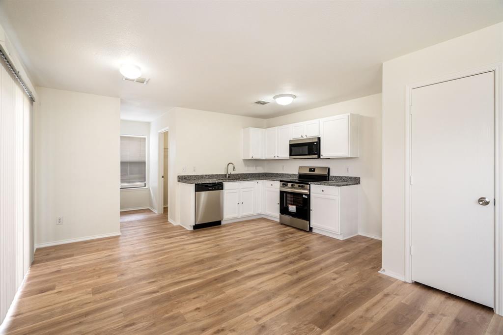 1626 White Oak Road Anna, TX 75409 - Photo 8 of 30 a kitchen with granite countertop a refrigerator and a stove top oven