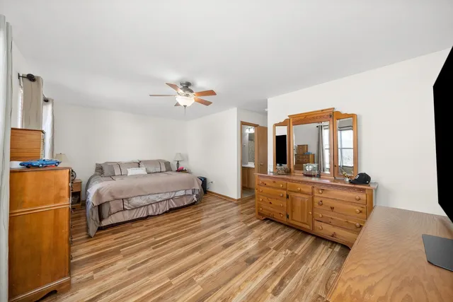 a spacious bedroom with a bed and wooden floor