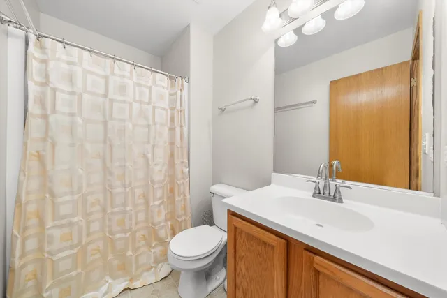 a bathroom with a sink a toilet and shower curtain