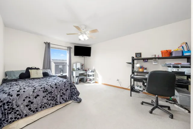 a bedroom with a bed a chair and a chandelier