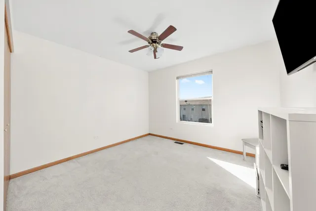 a view of a livingroom with a ceiling fan and window