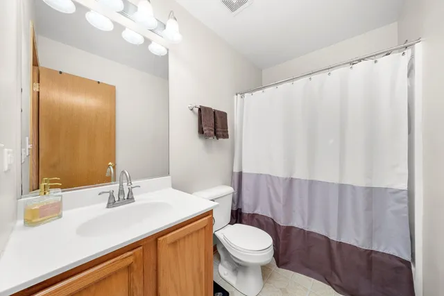 a bathroom with a sink vanity mirror and toilet