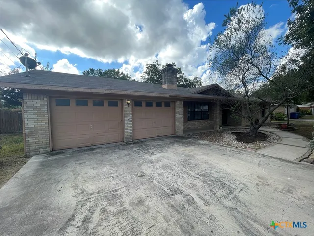 a view of a house with a yard and a garage