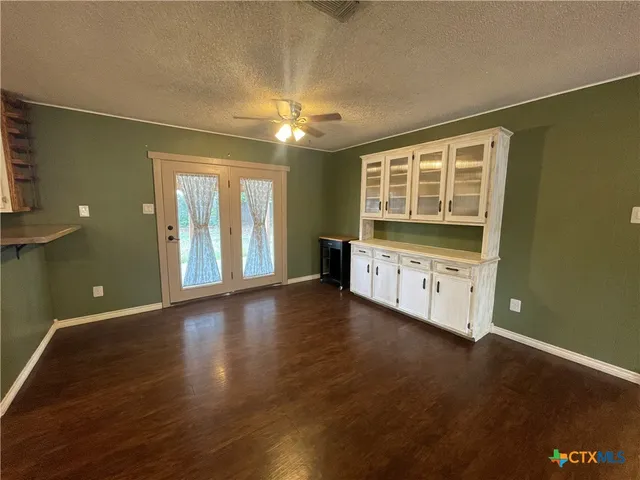 a view of empty room with wooden floor and window