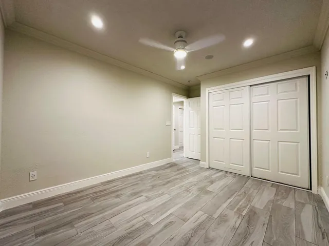 an empty room with wooden floor and closet area