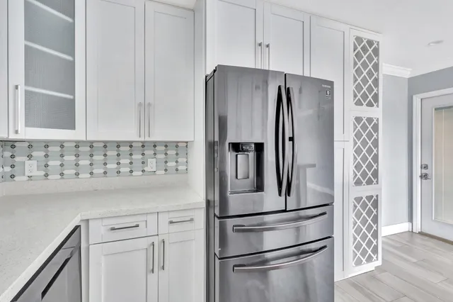 a kitchen with stainless steel appliances white cabinets and a refrigerator