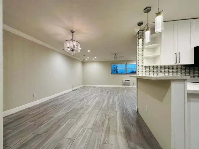 a view of a kitchen with a sink and dishwasher with wooden floor