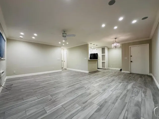 a view of empty room with wooden floor