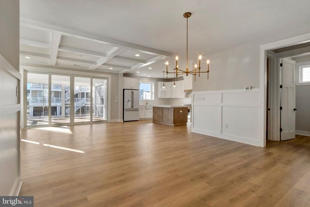 a view of a livingroom with wooden floor and hallway
