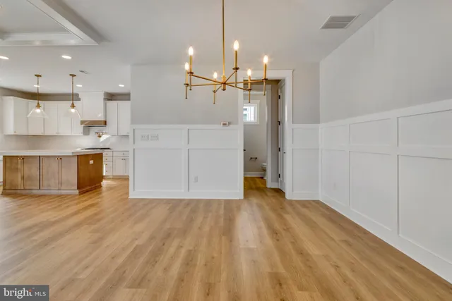 a large kitchen with cabinets and wooden floor
