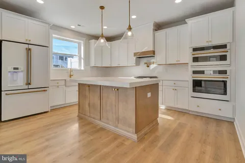 a view of a hallway with wooden floor and a cabinet