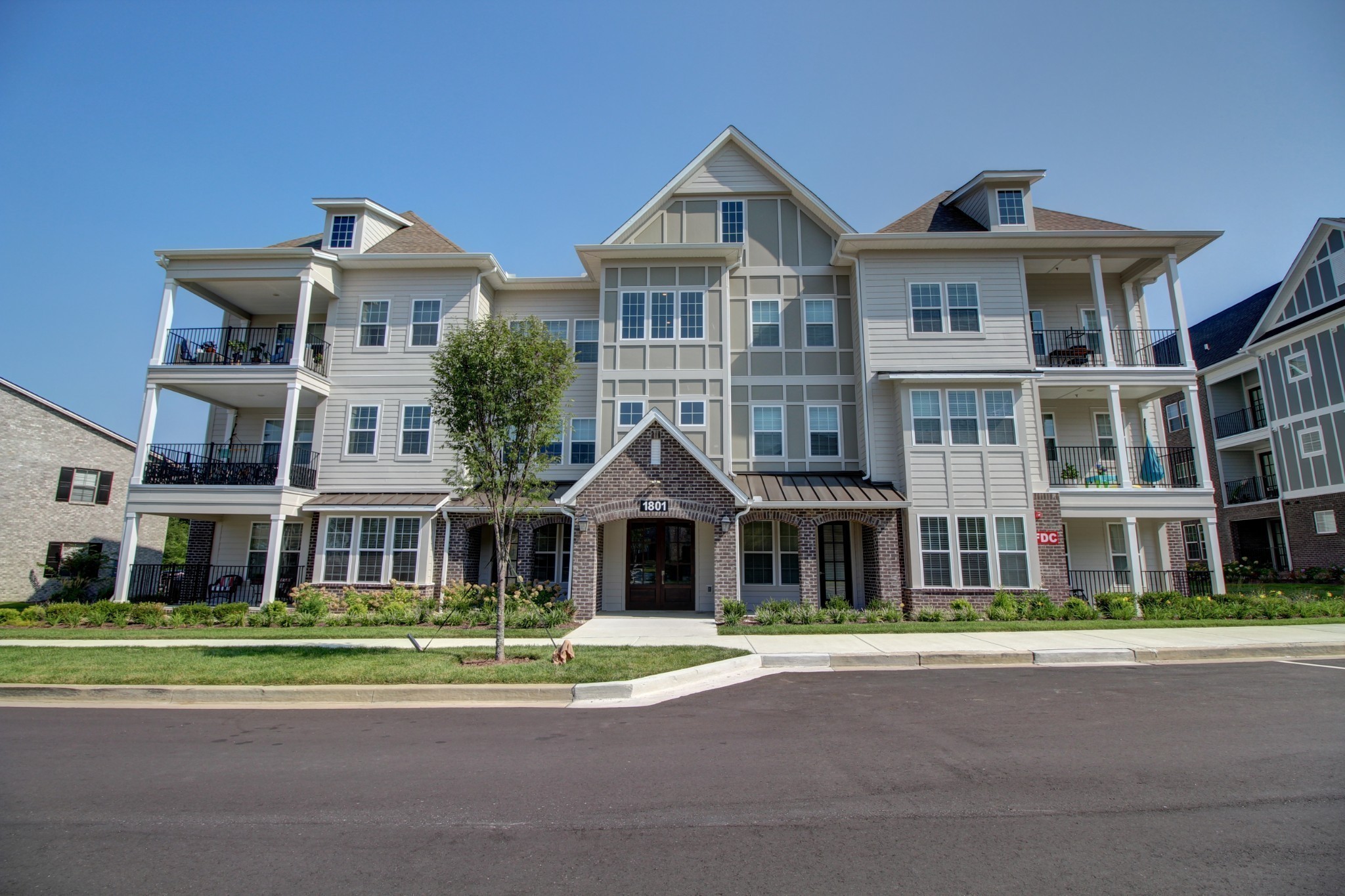 a front view of a residential apartment building with a yard
