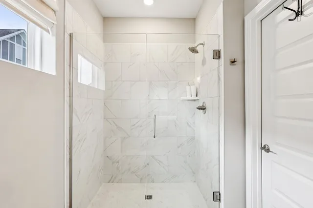 a bathroom with a shower a toilet and a window