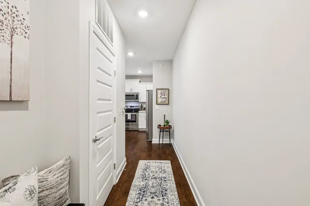 a walk in closet with wooden floor