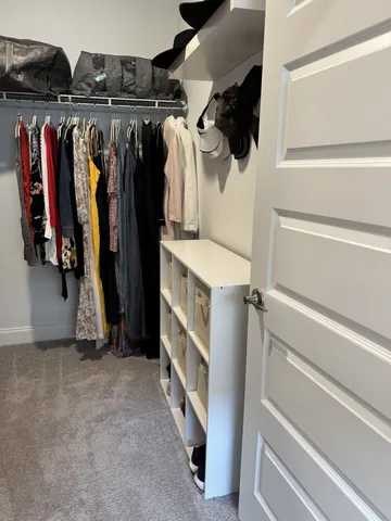 a view of walk in closet with clothes and shoes