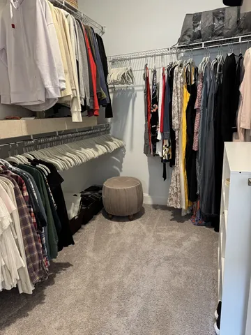 a view of walk in closet with clothes and shoes
