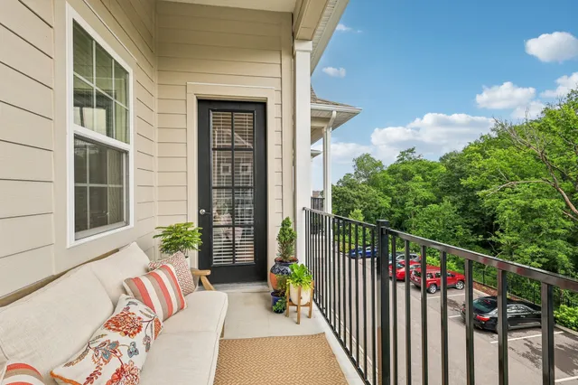 a balcony with furniture and a potted plant