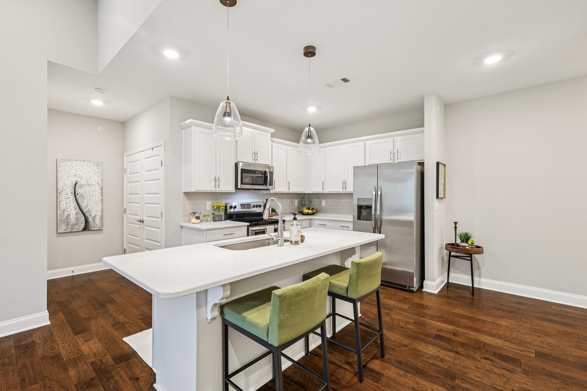 1801 Shadow Green Drive, Unit 306 Franklin, TN 37064 - Photo 3 of 39 a kitchen with stainless steel appliances a dining table chairs and wooden floor