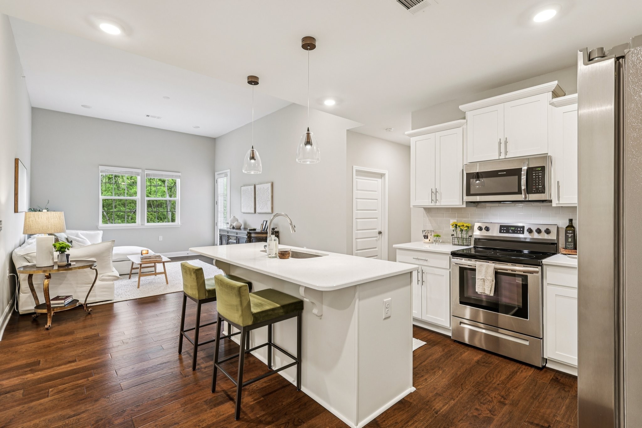 1801 Shadow Green Drive, Unit 306 Franklin, TN 37064 - Photo 4 of 39 a kitchen with stainless steel appliances granite countertop a stove a sink a microwave a refrigerator a dining table and chairs with wooden floor