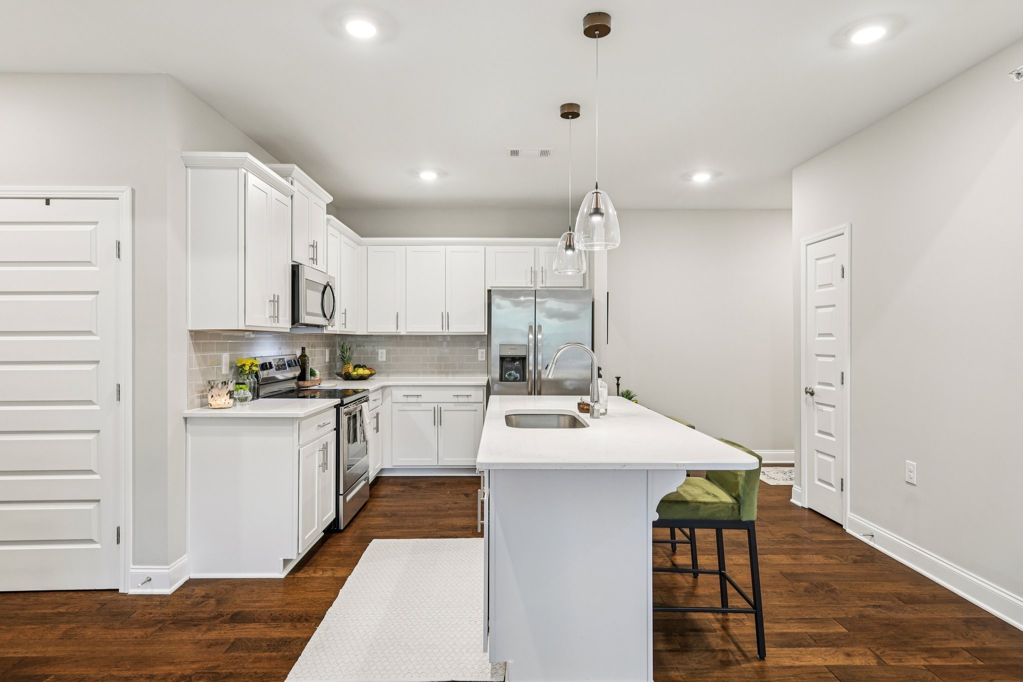 1801 Shadow Green Drive, Unit 306 Franklin, TN 37064 - Photo 6 of 39 a kitchen with a sink a stove a refrigerator and white cabinets with wooden floor