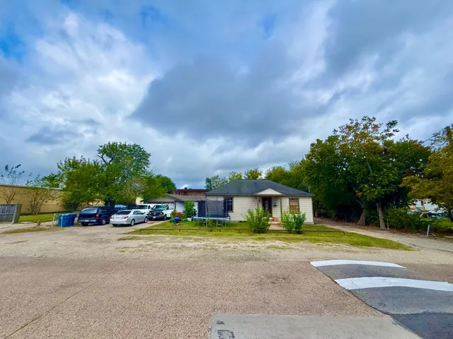 a view of a house with a swimming pool and a cars parked in front of it