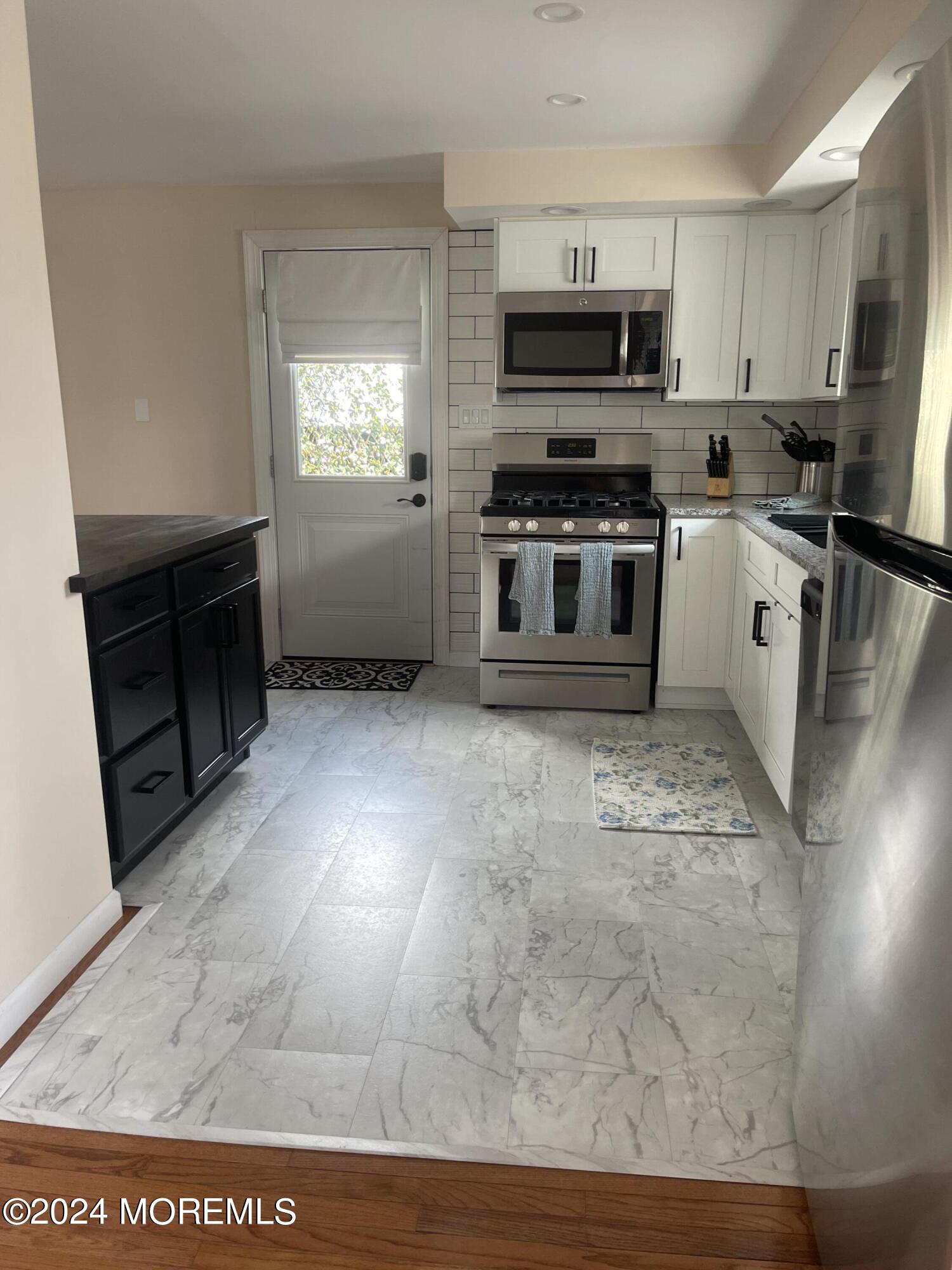 1407 River Road Belmar, NJ 07719 - Photo 4 of 26 a kitchen with stainless steel appliances a stove a sink a microwave a refrigerator a counter top space and cabinets
