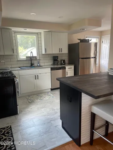 a kitchen with a refrigerator and a stove top oven