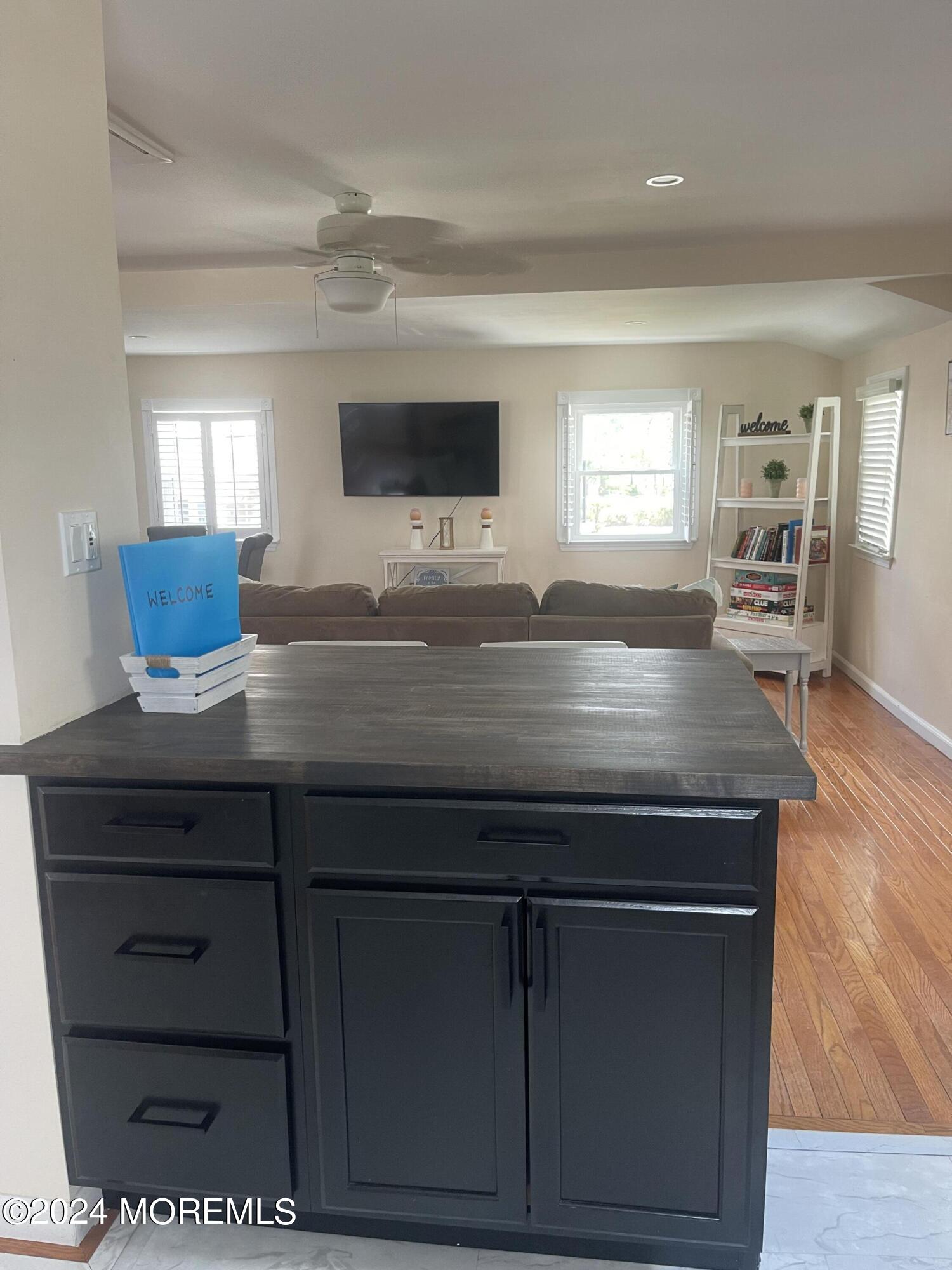1407 River Road Belmar, NJ 07719 - Photo 8 of 26 a kitchen with a wooden floor and cabinets