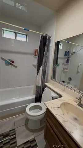 a bathroom with a granite countertop toilet sink and mirror