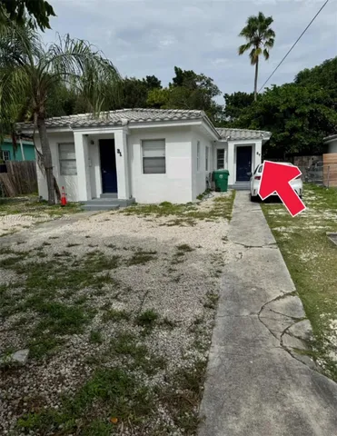 a backyard of a house with table and chairs