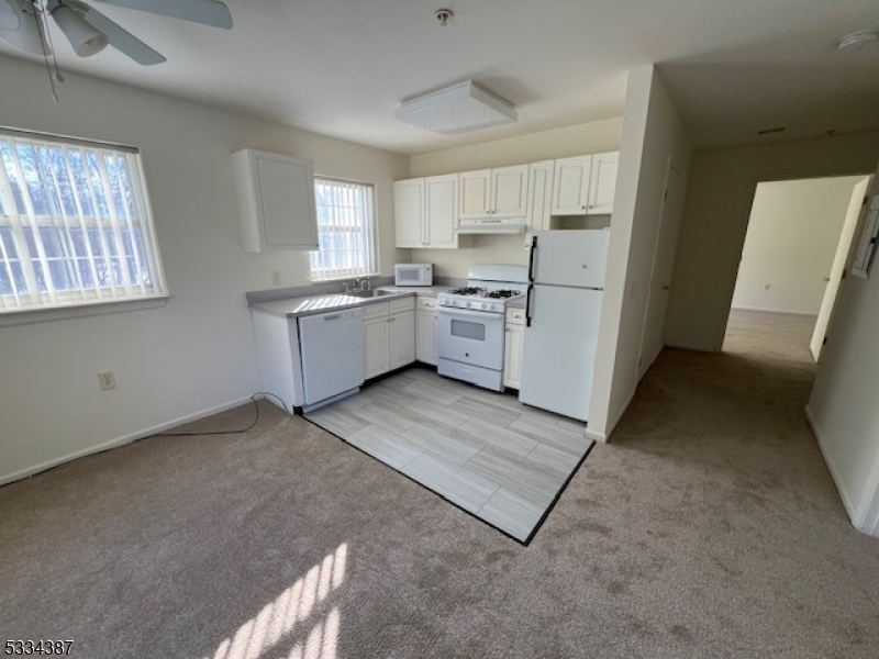 3203 Vail Road Parsippany, NJ 07054 - Photo 13 of 18 a kitchen with white cabinets and white appliances