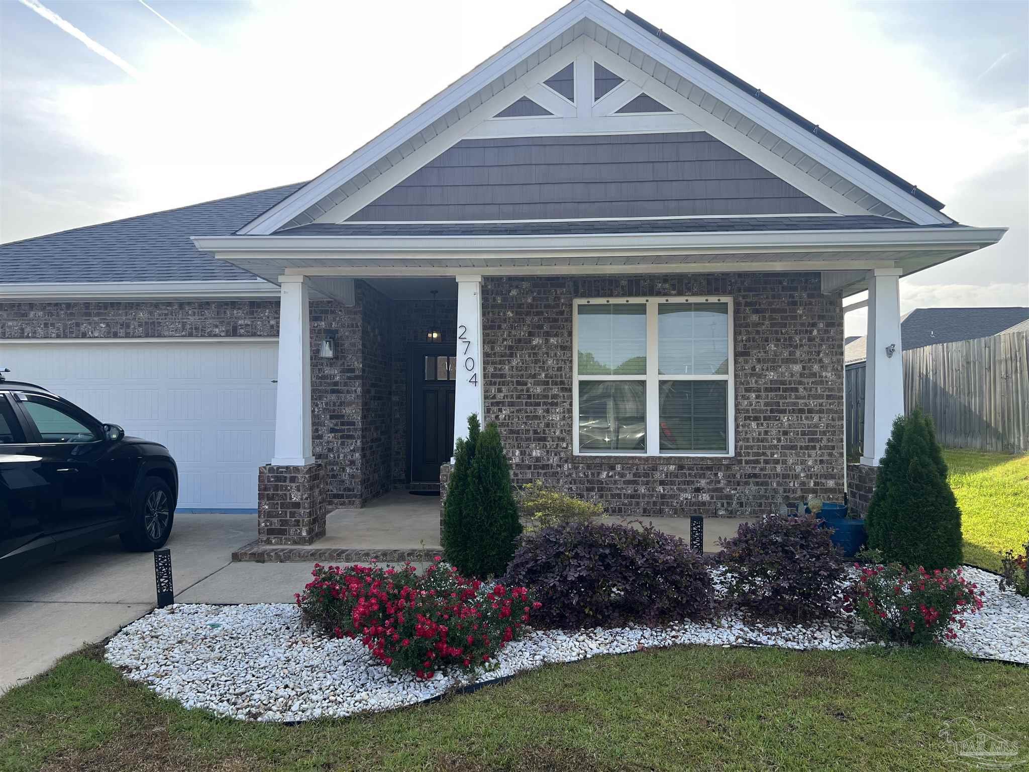 2704 Woodman Loop Cantonment, FL 32533 - Photo 1 of 44 a front view of a house with a garden