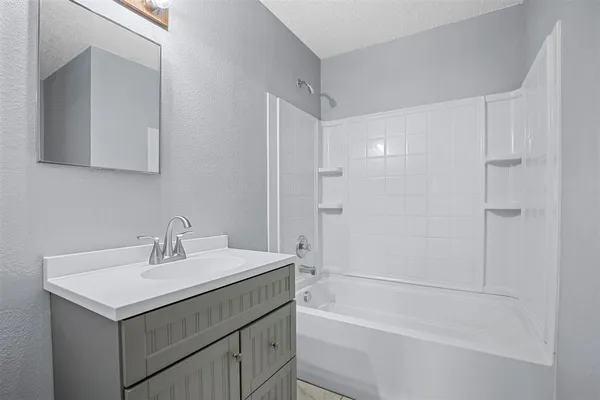 a view of an empty room with a chandelier fan