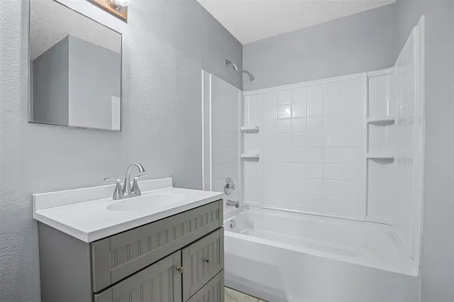 a view of an empty room with a chandelier fan