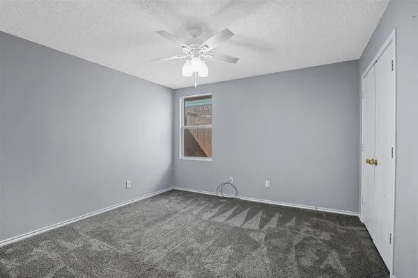 a view of an empty room with a ceiling fan