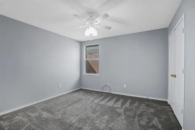 a view of an empty room with a ceiling fan