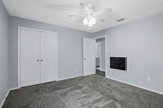 an empty room with a window and a fan