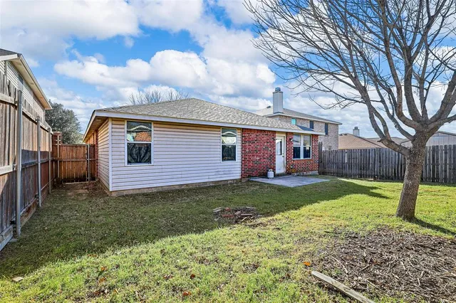 a view of a yard in front of a house with a large tree
