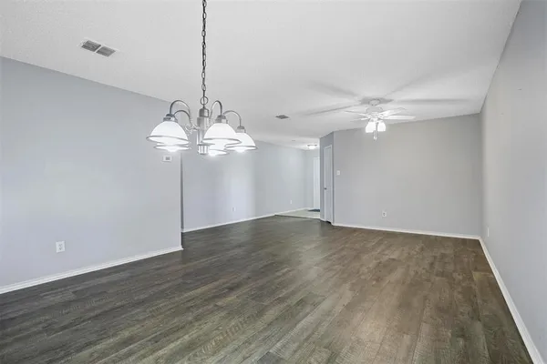 a view of a room with wooden floor and ceiling fan