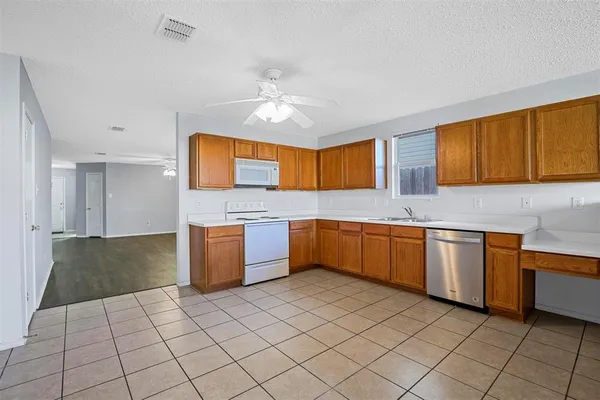 a kitchen with stainless steel appliances granite countertop a sink counter space cabinets and a window