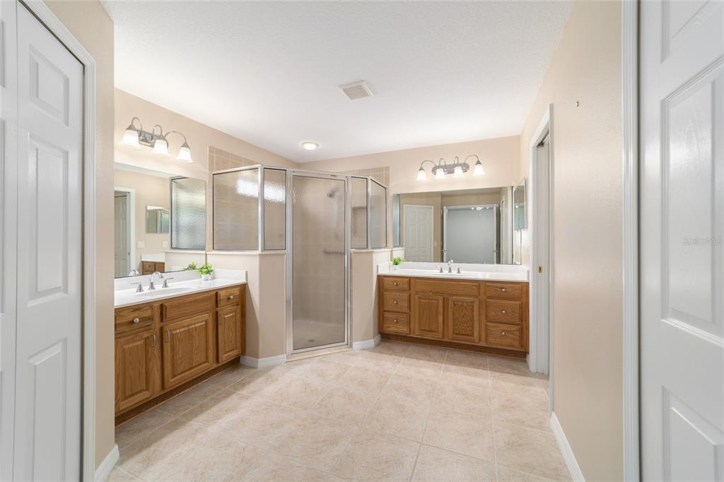 16369 Southwest 14th Avenue Road Ocala, FL 34473 - Photo 28 of 49 a large bathroom with a large mirror vanity and shower
