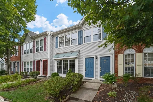 a front view of a house with garden and trees